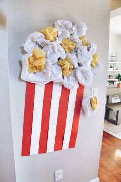 a bunch of flowers sitting on top of a red and white striped bag hanging from the side of a wall