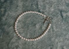 A darling silver filigree Rhodium cross graces this seed pearl bracelet that arrives in a gift box. The infant size is 4.5" and fits infant up to 2 year. Our 6" bracelet generally fits 2-9 years, and 7" fits 9-12 years. Measure her wrist just below the wrist bone to determine the best size. Our seed pearl collection necklaces and bracelets are strung by hand in Louisiana and finished with sterling silver closures. View the link below for the matching necklace. Cross Necklace Pearl White Pearl Bracelet For First Communion, Elegant Pearl Bracelet With Pearl Charm For First Communion, Adjustable Silver Pearl Bracelet For Baptism, Pearl Charm Bracelet For First Communion, Pearl Cross Necklace, Silver Cross-shaped Rosary Bracelet With 8mm Beads, Freshwater Pearl Bracelet, Pearl Collection, Seed Pearl