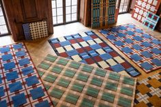 several rugs are laid out on the floor in an empty room with large windows