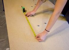 a woman is measuring the floor with a tape