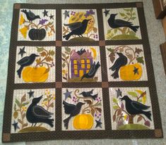 a quilt with black birds and pumpkins on it