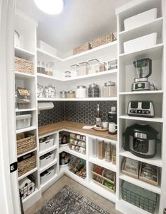 an organized pantry with white shelving and lots of storage space on the side wall