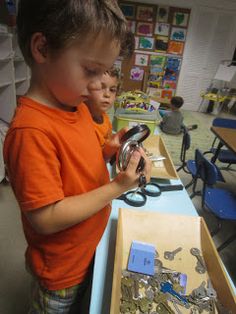 two young boys playing with scissors in a classroom