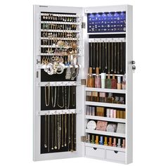 a white jewelry cabinet filled with lots of necklaces and bracelets hanging from it's doors