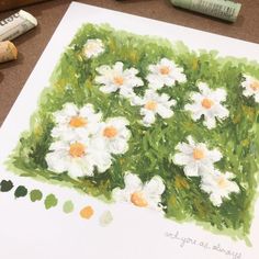 a painting of daisies in the grass with crayons next to it and markers