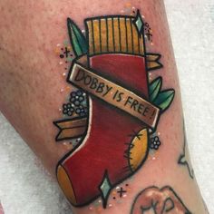 a person with a tattoo on their leg that says dobby is free and an elephant