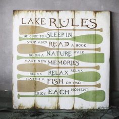 a wooden sign that says lake rules on the side of a building with ivy growing around it