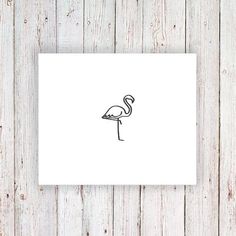 a black and white drawing of a flamingo on a piece of paper next to a wooden wall