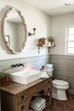 a bathroom with a sink, toilet and mirror