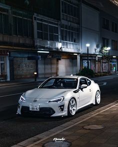 a white sports car parked on the street at night