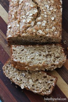 three slices of banana bread sitting on top of a wooden cutting board with oats