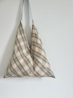 a triangle shaped pillow hanging on the wall