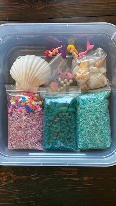 a plastic container filled with lots of different types of beads and seashells in it