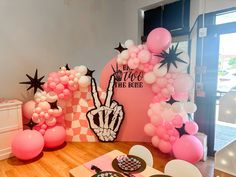 the table is set up with balloons, plates and utensils