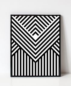 a black and white art piece with lines on the bottom, in front of a white wall