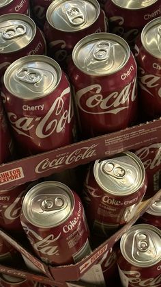 many cans of coca - cola are stacked on top of each other