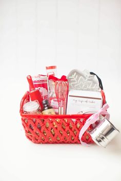 a red basket filled with lots of different types of items on top of a white table