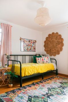 a room with a bed, rug and pictures on the wall