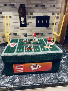 a cake made to look like a football field with people playing on the field in it