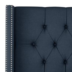 a blue upholstered headboard with buttons and studding on the top side