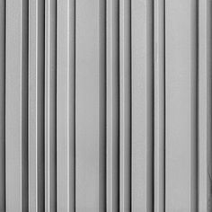 a black and white photo of the side of a building with vertical lines painted on it