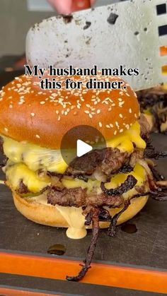 a hamburger sitting on top of a wooden table next to a burger bun with cheese and other toppings