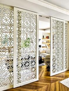 a living room with wooden floors and white walls, an open door to the outside