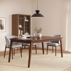 a dining room table and chairs in front of a bookcase with books on it