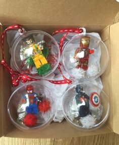 four glass ornaments in a box on a table