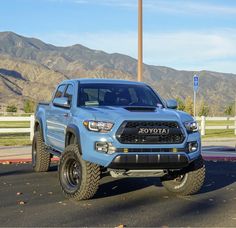 a blue toyota truck parked in front of a parking lot