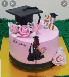 a pink cake decorated with flowers and a graduate's cap