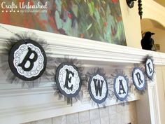 a mantle decorated with black and white paper cutouts that spell out the word beware