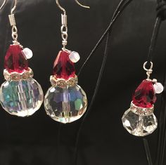 three pairs of earrings with red and clear beads