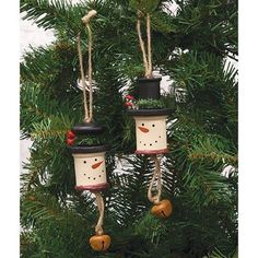 three snowman ornaments hanging from a christmas tree