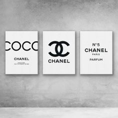 three chanel posters are hanging on the wall in a minimalistic room with concrete flooring