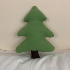 a green felt christmas tree sitting on top of a bed