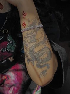 a woman with a dragon tattoo on her arm