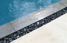 an empty swimming pool with rocks in the water