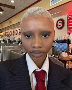 a woman with shaved hair wearing a suit and tie