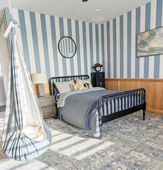 a bedroom with blue and white striped walls