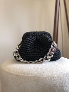 a black crocheted hat sitting on top of a white stool