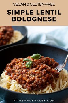 a bowl filled with spaghetti and sauce on top of a blue cloth next to a fork