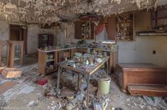 an old run down kitchen with lots of clutter on the floor and ceiling,