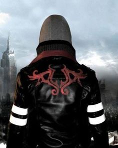 a man wearing a black leather jacket with red and white designs on his back, standing in front of a cityscape