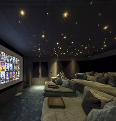 a home theater with two couches and a projector screen in the middle of the room