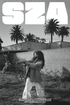 a woman holding a tennis racquet on top of a grass covered field with palm trees in the background