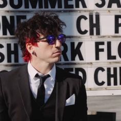 a man with red hair wearing sunglasses and a suit