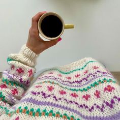 a woman holding a cup of coffee in her hand