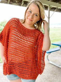 a woman wearing an orange crochet top posing for the camera