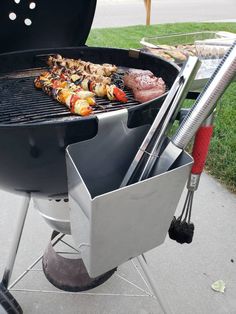 a bbq grill with meat and vegetables cooking on it's side burners